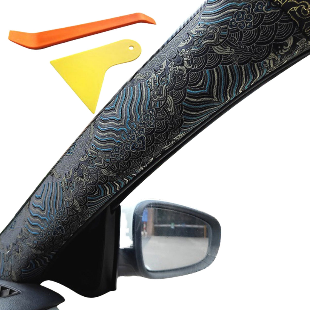 Blue embroidered wrap fitted to a car A-pillar, with a pry tool and scraper