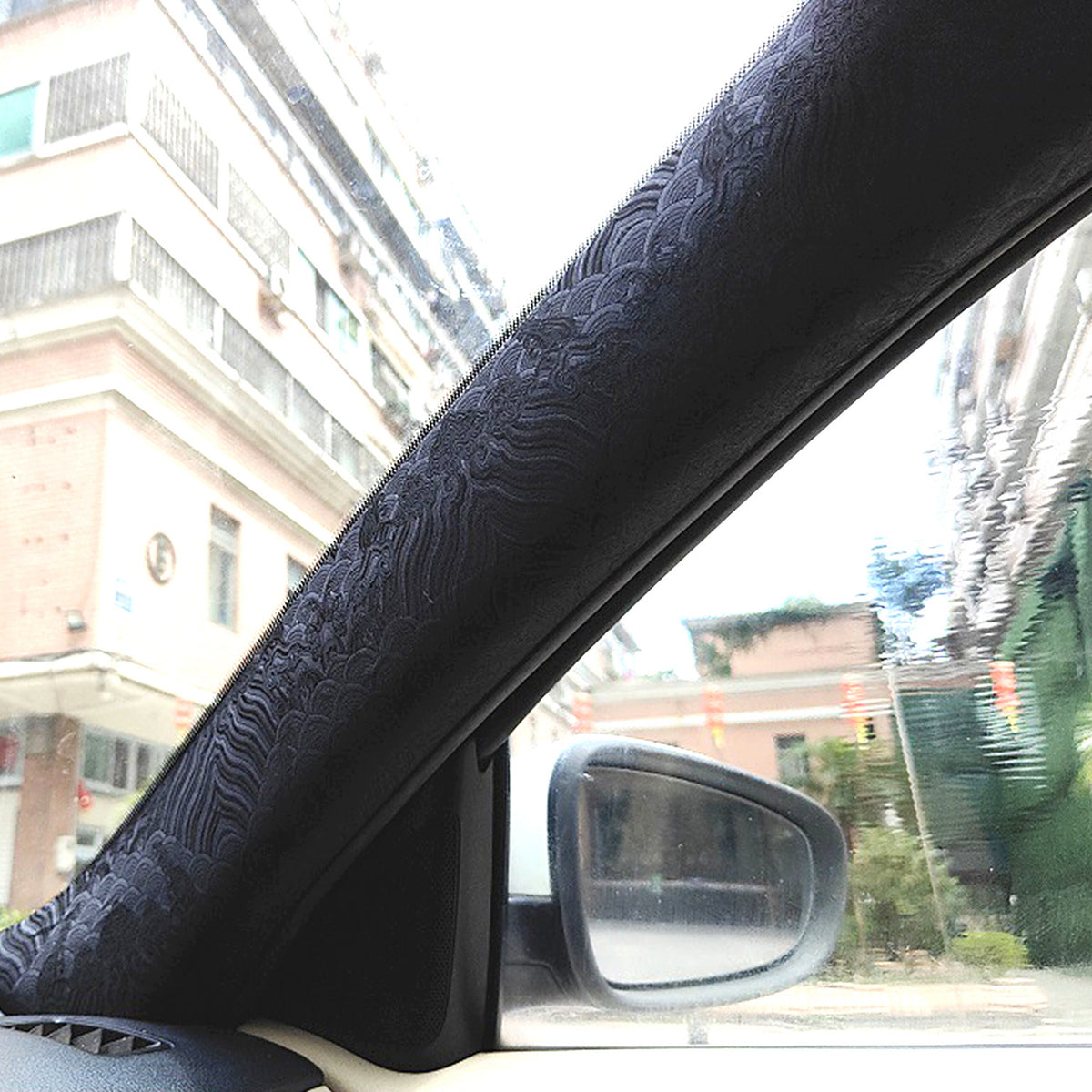 Black embroidered wrap fitted to a car A-pillar
