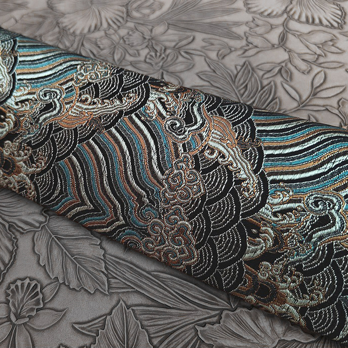Close-up of the blue embroidered wrap's wave and cloud pattern