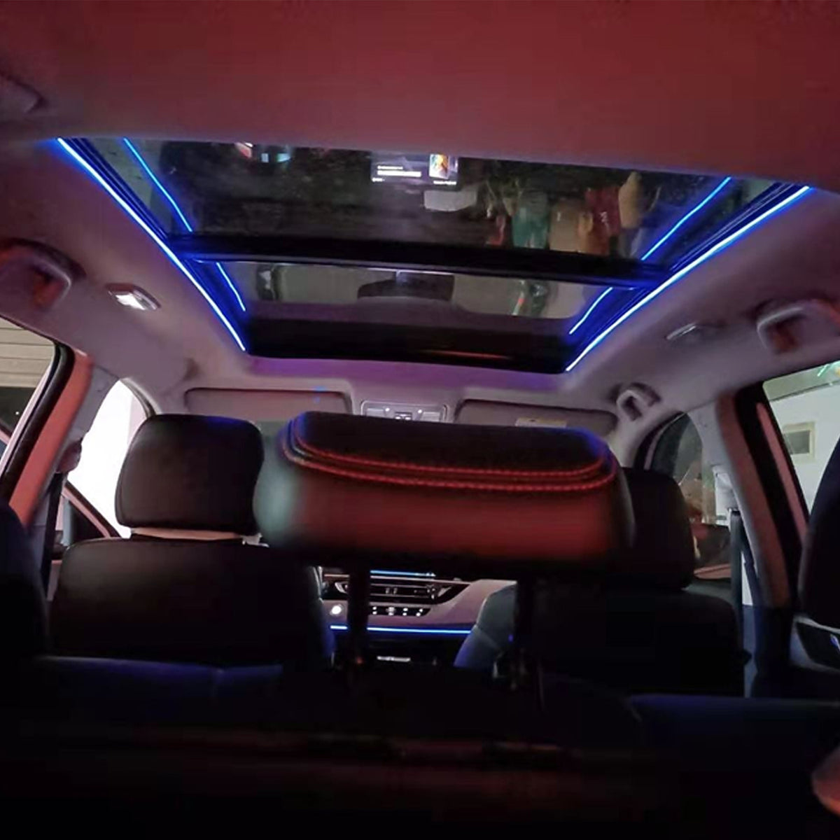 Car interior with blue ambient light strips around the panoramic sunroof