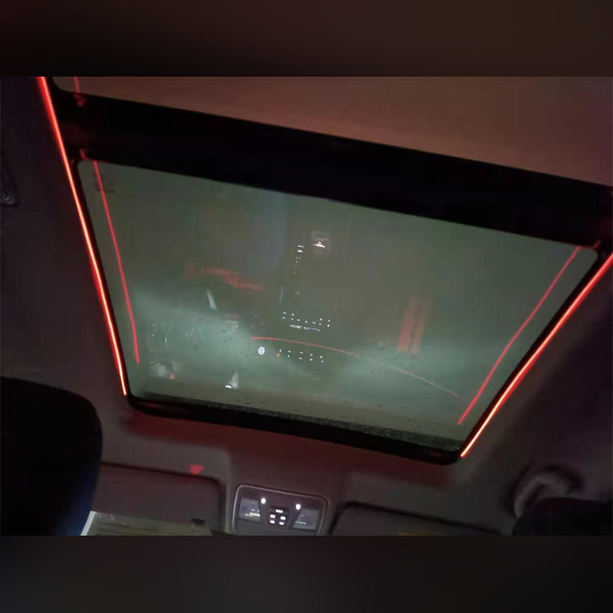 Red ambient light strips along both sides of a sunroof at night